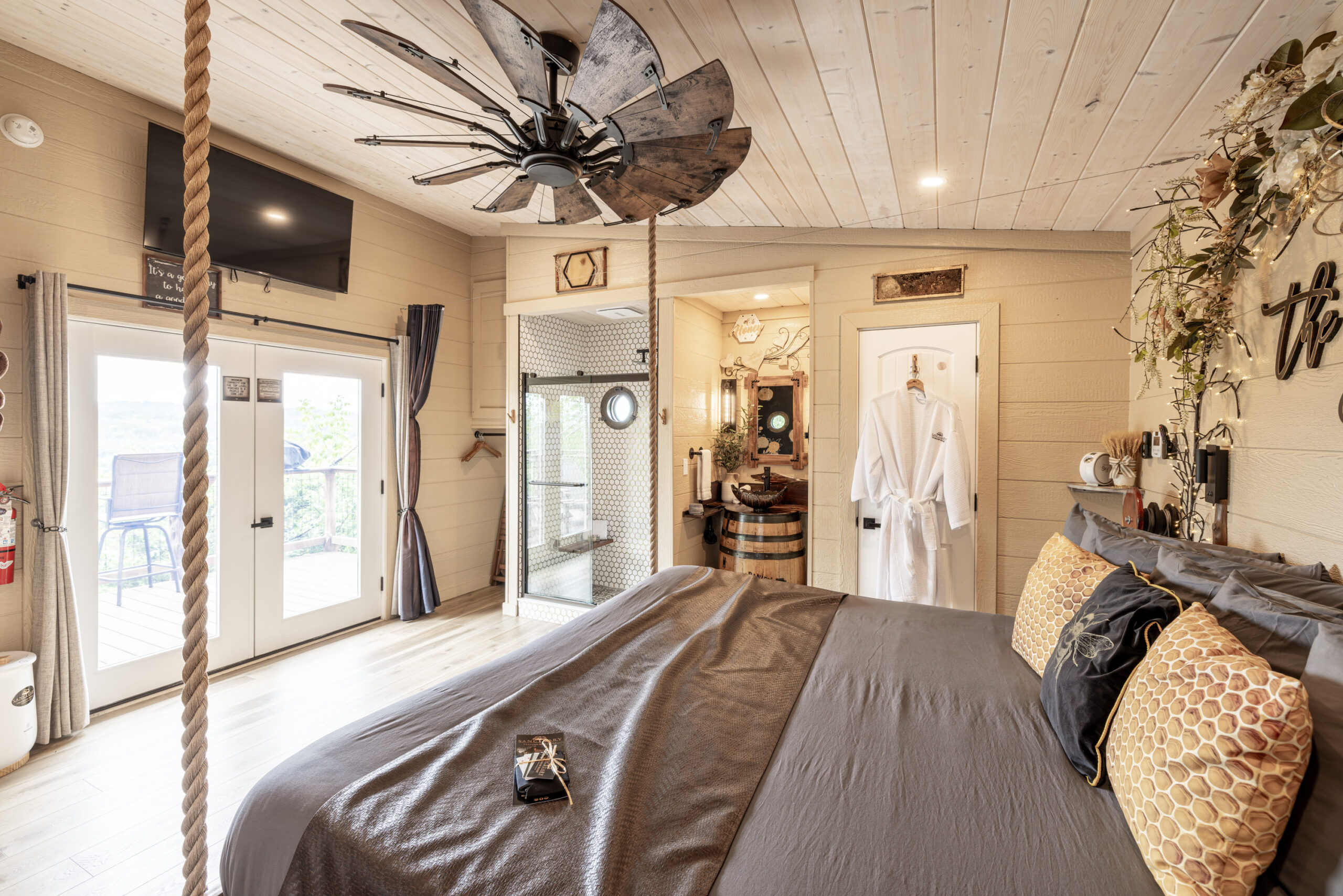 Luxe treehouse interior with a king bed and complimentary robes waiting for two