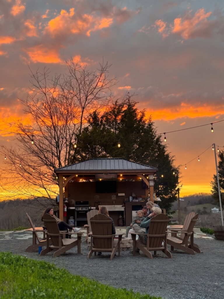 Guests gathered around the Basecamp firepit at sunset