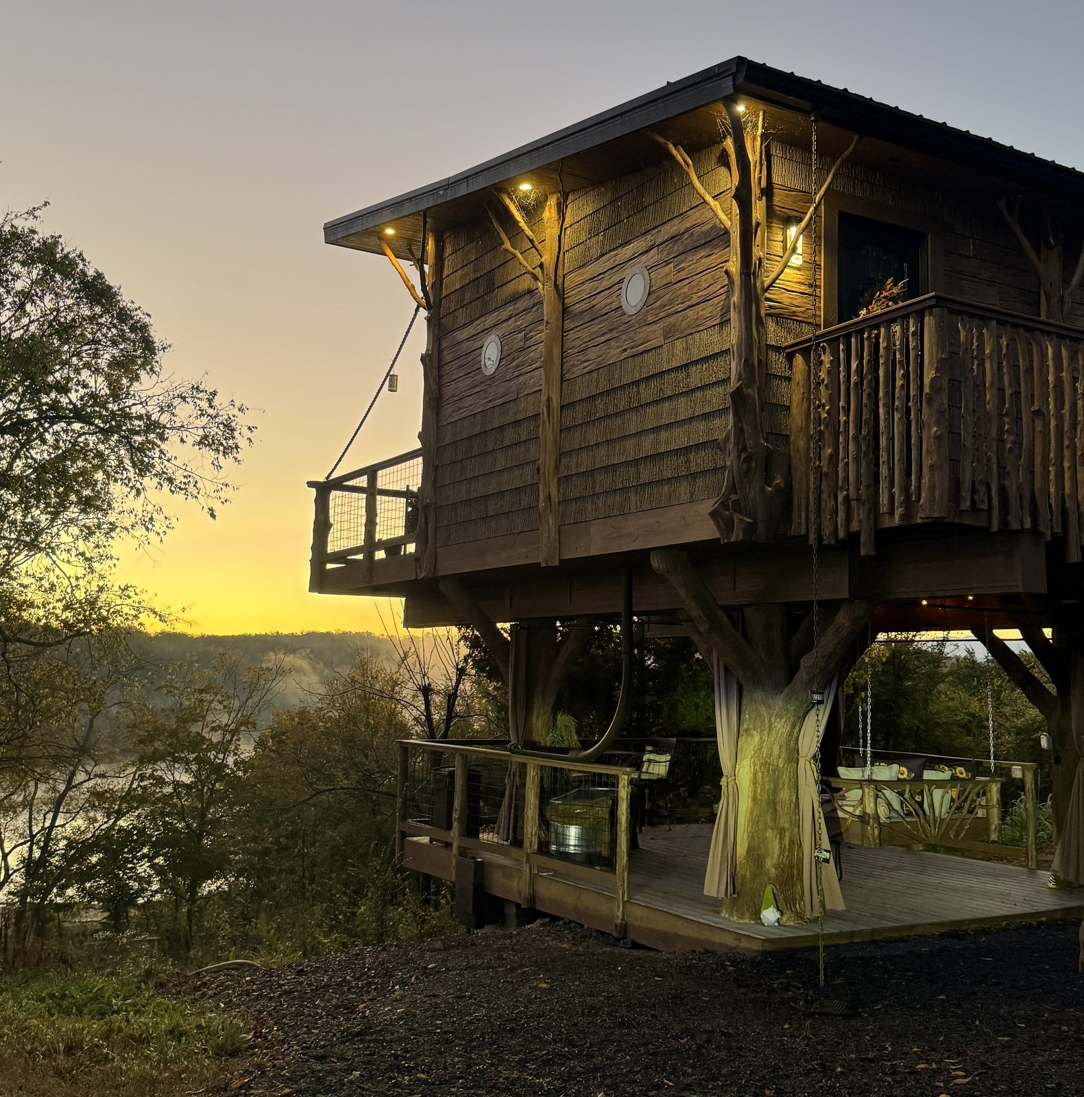 Honey Hole Luxe treehouse glowing at sunset in October, the setting for a fall treehouse getaway in the Smoky Mountains at Sanctuary Treehouse Resort
