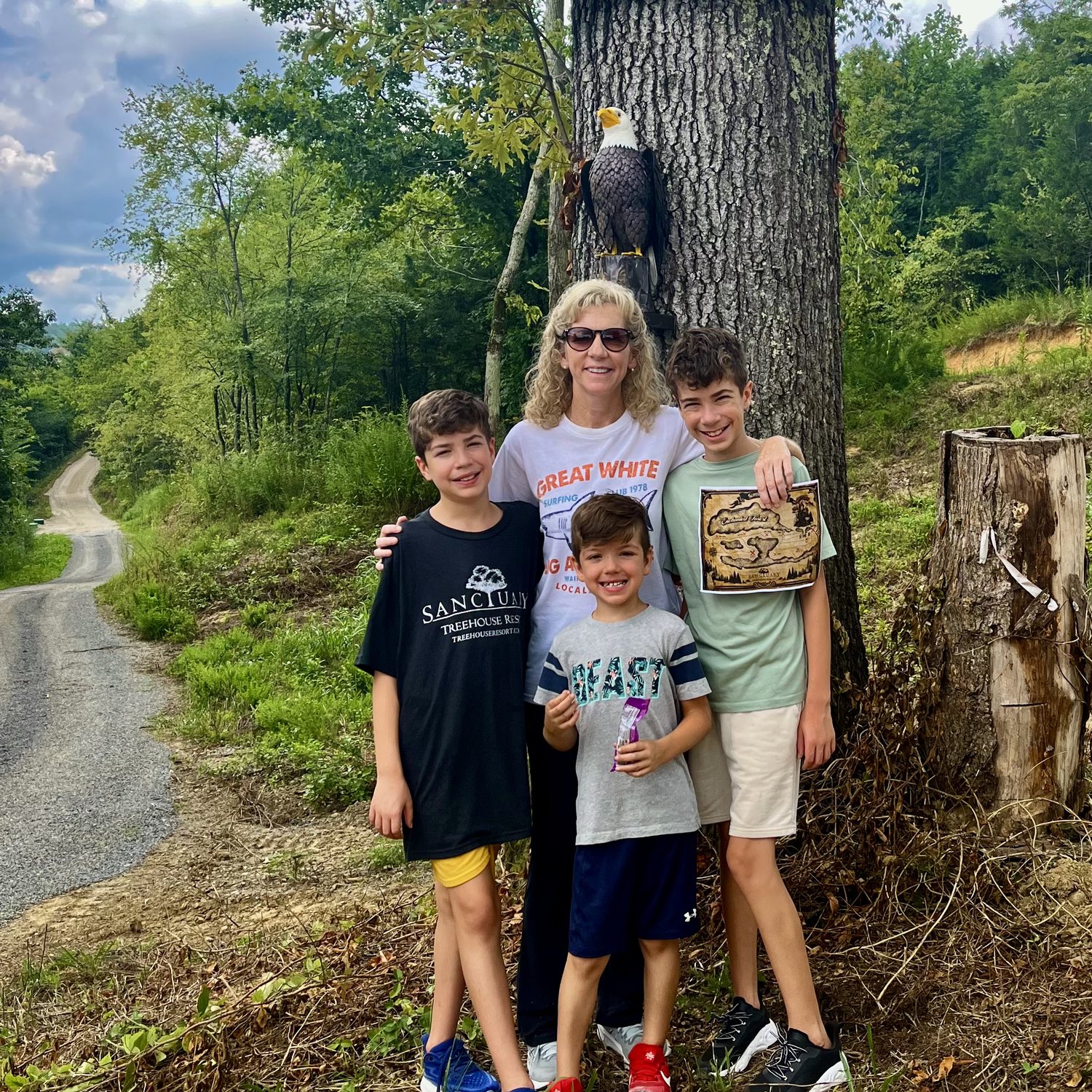 A family on the one-mile scavenger hunt trail at Sanctuary Treehouse Resort, map in hand